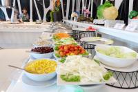 una linea a buffet con ciotole di diversi tipi di cibo di Grand Hill Resort and Spa a Nakhon Sawan