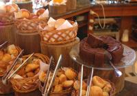 a display of cakes and pastries in baskets on a counter at Canto da Floresta Ecoresort in Amparo