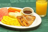 a plate of food with meat and fruit and a drink at Balmoral Hotel San José CR, Historic District in San José