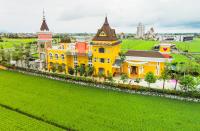 a yellow building with a clock tower on a green field at Jane Castle in Wujie