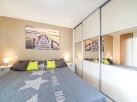 a bedroom with a large bed with yellow pillows at Appartement Villa Quietude in Bagnols-en-Forêt