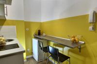 a kitchen with yellow and white walls and a counter with two chairs at Les Appartements d&#39;Edmond Sylvabelle in Marseille