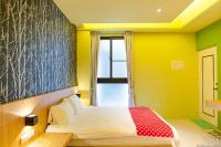 a bedroom with yellow walls and a bed with a red blanket at Yellow Kite Hostel in Tainan