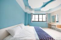 a blue bedroom with a bed and a window at Yellow Kite Hostel in Tainan