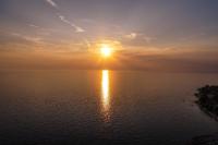 a sunset over the water with the sun in the sky at Apartments Villa Adamović in Umag