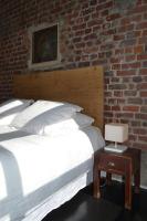 a bedroom with two beds and a brick wall at Chambre d&#39;hôtes la Teinturerie in Roubaix