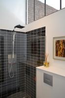 a bathroom with a shower with black tiles at Chambre d&#39;hôtes la Teinturerie in Roubaix