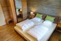 a bedroom with a bed with white pillows and a mirror at Camping Bissen in Esch-sur-Sûre