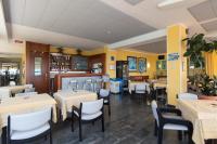 een restaurant met witte tafels en stoelen en gele muren bij Hotel Bellevue Et Mediterranée in Diano Marina