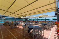 een buitenterras met tafels, stoelen en parasols bij Hotel Bellevue Et Mediterranée in Diano Marina
