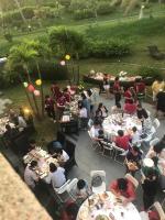 a group of people sitting at tables in a garden at Kenting 4 Sisters Villa in Eluan
