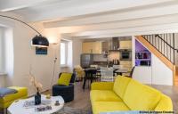 a living room with a yellow couch and a kitchen at Le Gîte du Port in Roscoff