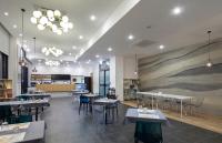 un restaurante con mesas y sillas y una gran pintura en la pared en Gangneung City Hotel, en Gangneung