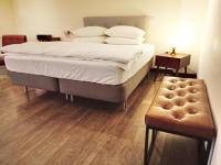a bedroom with a large bed and a wooden floor at HomeStay LB in Taitung City