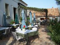 un patio al aire libre con mesas y sombrillas en Káli Art Inn, en Köveskál