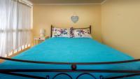 a bedroom with a bed with a blue comforter at Amazing House in Halki in Halki