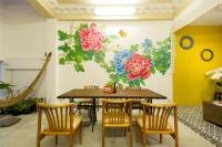 comedor con mesa y sillas con un mural de flores en The Neighbors Hostel, en Phuket