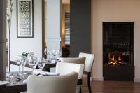 een eetkamer met een tafel met wijnglazen en een open haard bij Sandy Cove Hotel in Ilfracombe