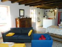 a living room with a blue couch and a kitchen at Comfortable holiday home with garden in Sainte-Croix-de-Beaumont