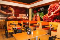 een restaurant met tafels en een muurschildering van eten bij Hotel Ruinas Resort in Huehuetenango