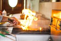 een persoon kookt eten op een grill bij Hotel Ruinas Resort in Huehuetenango
