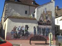a mural of a group of people on the side of a building at Aux Cornettes in Beaune