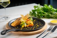 een bord eten op tafel met een glas wijn bij Blanc Smith Residence in Siem Reap