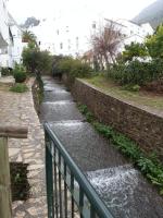 a stone walkway with a fence next to a creek at Casa Rural La Verdura in Ubrique