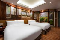 two beds in a room with two windows at Shichi Hotel in Kaohsiung