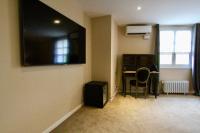 a living room with a flat screen tv on the wall at Hotel Restaurant Le Maréchal - Teritoria in Colmar