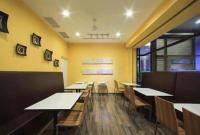 a dining room with tables and chairs and yellow walls at CHECK inn Express Taichung Fengchia in Taichung