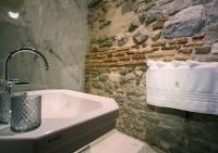 a bathroom with a sink and a stone wall at Heritage Hotel Cardo in Split