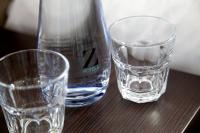 two glasses and a bottle of water on a table at The Z Hotel Liverpool in Liverpool
