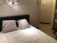 a bed with white sheets and pillows in a room at Studio 2 pers en vieille ville parking gratuit - by La Source d&#39;OrFée in Boulogne-sur-Mer