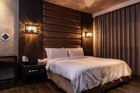 a bedroom with a large bed with a wooden headboard at The Riverside Hotel Fashion in Kaohsiung