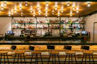 a bar with stools in front of a counter with alcohol at Bobby Hotel in Nashville