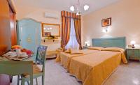 a bedroom with two beds and a table and a dining room at Hotel Henry in Venice