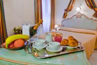a tray of breakfast food on a table in a bedroom at Hotel Henry in Venice