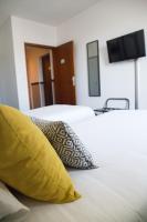 Una habitación de hotel con dos camas con almohadas amarillas y un televisor. en Sure Hotel by Best Western Angouleme, en Angulema