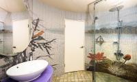 a bathroom with a sink and a glass shower at Shichi Hotel in Kaohsiung