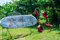 a surfboard with writing on it sitting in the grass at Sea-Hi B&amp;B in Yanliau