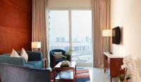 a living room with a couch and chairs and a large window at Treppan Hotel & Suites By Fakhruddin in Dubai