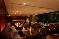 ein Restaurant mit Tischen und Stühlen und einem großen Fenster in der Unterkunft Sora Resort & Suites Sukhumvit in Bangkok