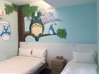 two beds in a room with a painting of a cow on a tree at Light Blue Hostel in Hengchun South Gate
