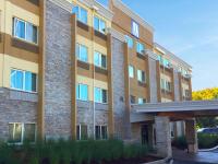 Un edificio de apartamentos con un estacionamiento enfrente. en Comfort Inn &amp; Suites Tigard near Washington Square, en Tigard