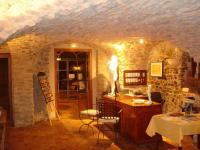 Cette chambre est dotée d&#39;un mur en pierre avec une table et des chaises. dans l&#39;établissement Le Clos des Arts, à Les Mages