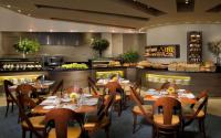 ein Restaurant mit Tischen und Stühlen und einer Küche in der Unterkunft Dan Eilat Hotel in Eilat