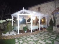 un cenador blanco en un patio por la noche en Posada del Indiano, en Cidones