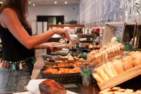 Eine Frau serviert Essen am Buffet in der Unterkunft Ibersol Antemare - Adults Only in Sitges