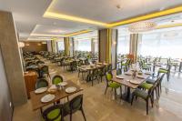 a restaurant with tables and chairs in a room at Hotel Olanesti & Spa Medical in Băile Olăneşti